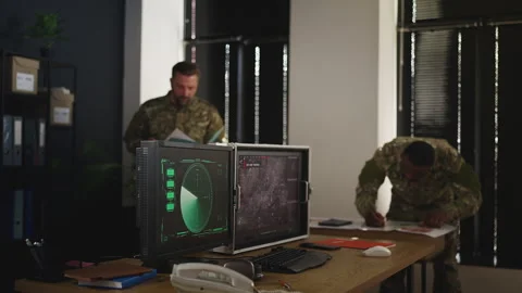 Servicemen planning tactical operation in command center using detailed maps Stock Footage 333308199