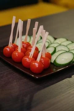 A serving of appetizer made with fresh cherry tomatoes on skewers and cucumbe Stock Photos