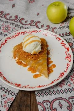A serving of apple pie with vanilla ice cream on a plate. Stock Photos
