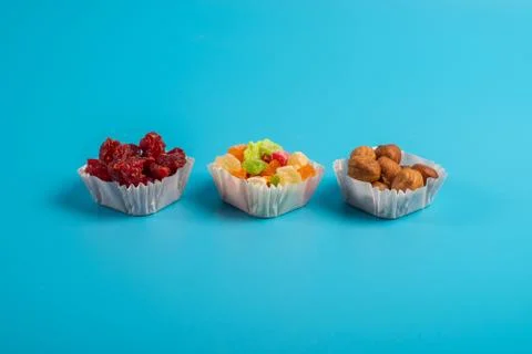 A serving of assorted candied fruit, dried cherries and hazelnuts in paper mu Stock Photos