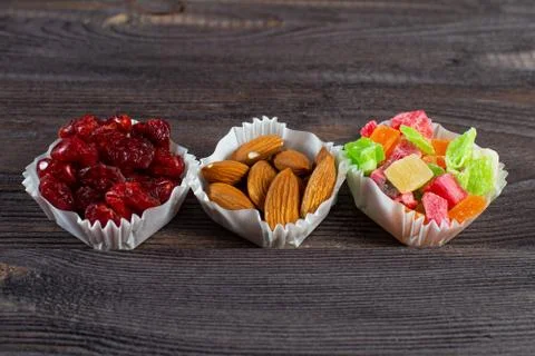 A serving of assorted candied fruit, dried cherries and hazelnuts in paper mu Stock Photos