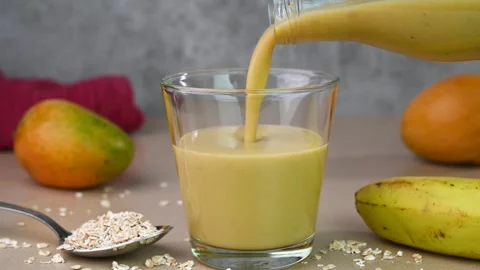 Serving banana mango oat smoothie Stock Footage 308320470