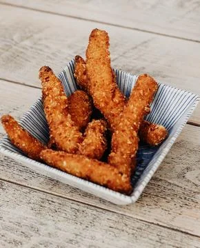 Serving of battered and fried chicken drumsticks Stock Photos