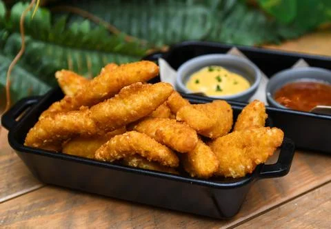 Serving of battered and fried chicken fingers Stock Photos