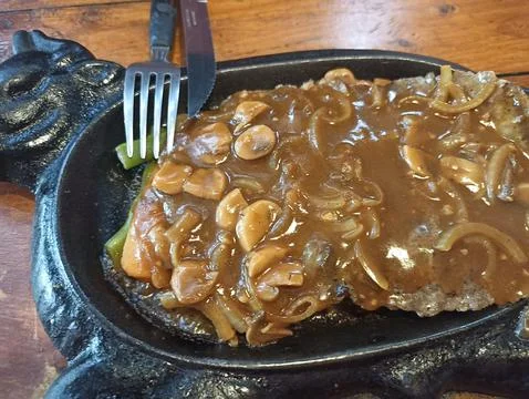 A serving of beef steak with black pepper mushroom sauce Stock Photos