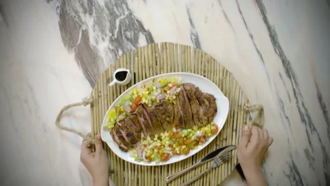 Serving a beef steak plate with sauce and salad, top view Stock Footage 135477512