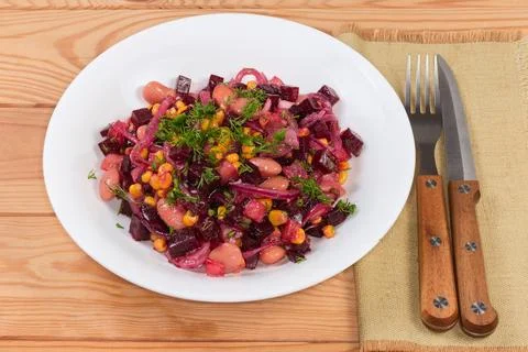 Serving of the beetroot salad on dish on rustic table Фото