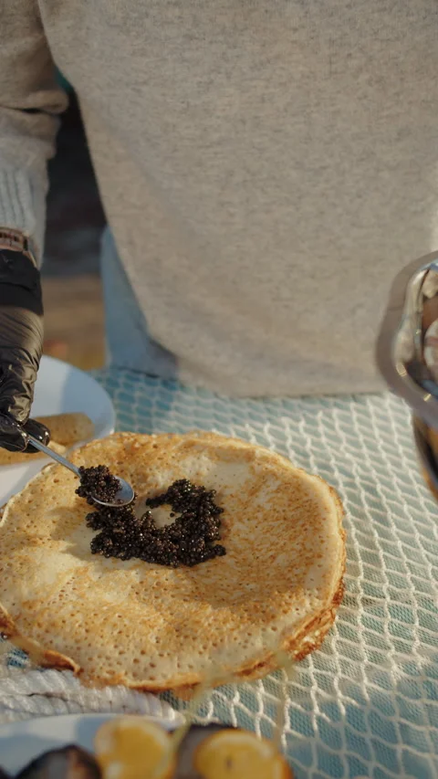 Serving black caviar on thin pancake Stock Footage 310006504