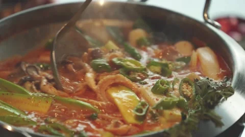 Serving Bubbling Korean Stew from Pot with Ladle Close Up 4K Stock Footage 334697709