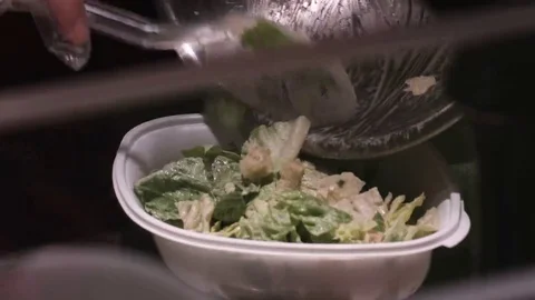Serving caesar salad into a client's bowl in a restaurant Stock Footage 69231916