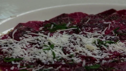 Serving carpaccio meat dish falling parmesan cheese HD slow motion video Stock Footage 70007025