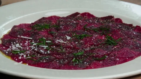 Serving carpaccio meat dish parmesan falling cheese slow motion HD video Stock Footage 70006993