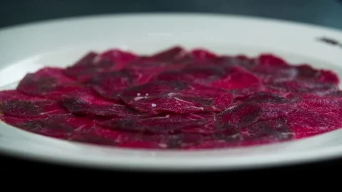 Serving carpaccio meat dish with salt HD slow motion сlose up HD video. Stock Footage 70004070