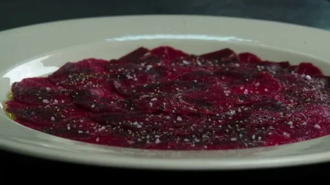 Serving carpaccio meat dish with spice slow motion сlose up HD video Stock Footage 70003773