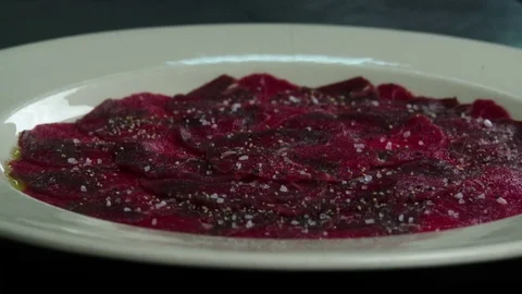 Serving carpaccio meat dish spice falling slow motion сlose up HD video Stock Footage 70007492