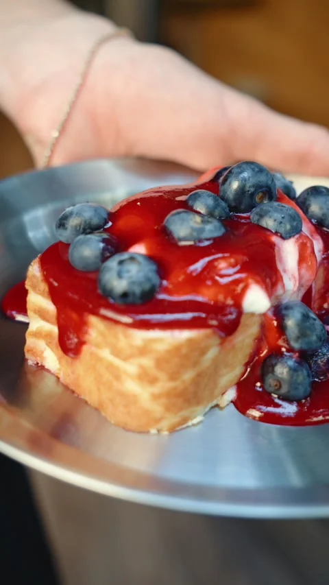 Serving Cheesecake with Raspberry Sauce and Blueberries Stock Footage 342924361