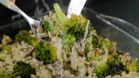 Serving Creamy Broccoli Casserole with Utensils at Cooking Video stock 341420106