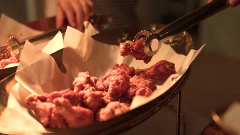 Serving Crispy Fried Chicken Wings with Tongs at a Buffet Stock-Footage 340374549