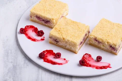 Serving of delicious fruit vanilla cake pieces on a white plate Stock Photos