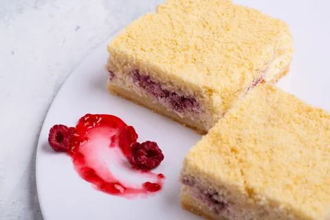 Serving of delicious fruit vanilla cake pieces on a white plate Stock Photos