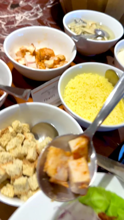 Serving Diced Grilled Chicken onto a Fresh Salad at a Buffet Stock Footage 335799597