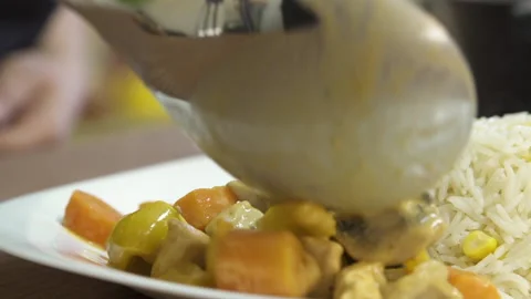 Serving a dish of chicken curry and vegetables with rice, close up Stock Footage 154247051