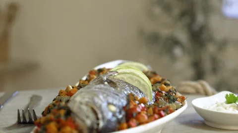 Serving a dish of roasted fish with vegetables and sauce Stock Footage 135279185