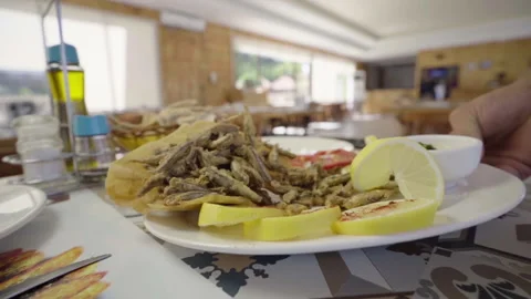 Serving a dish of sardines fried fish on a restaurant table Stock Footage 155418550