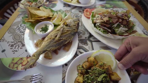 Serving a dish of sea bream fish with various Lebanese cuisine appetizer dishes Stock-Footage 155418655
