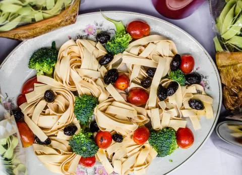 Serving example of pasta with broccoli, olives, and cherry tomatoes Stock Photos