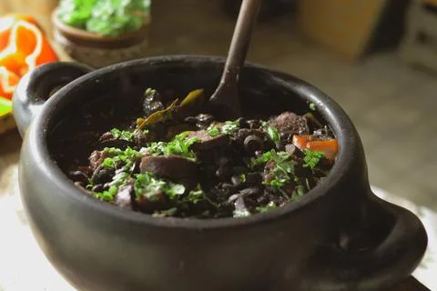 Serving feijoada, a Brazilian dish on a lunch table Stock Photos