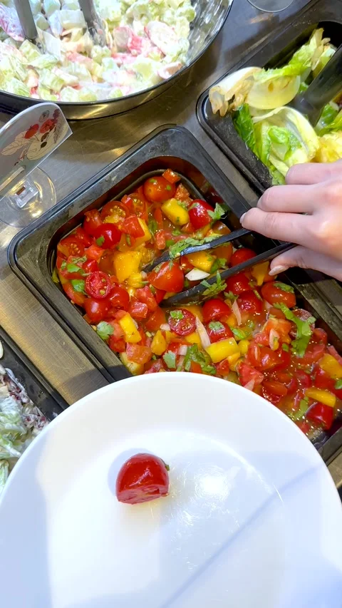 Serving Fresh Cherry Tomato Salad from a Buffet Bar with Tongs Stock Footage 335797615