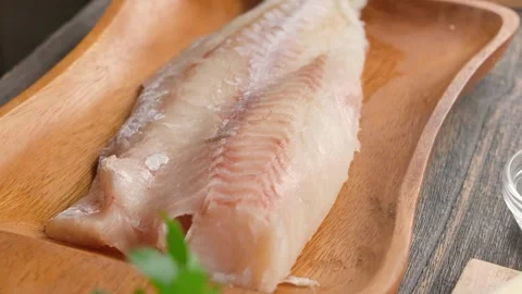 Serving fresh raw cod fillet in a rustic wooden bowl Video stock 316914653