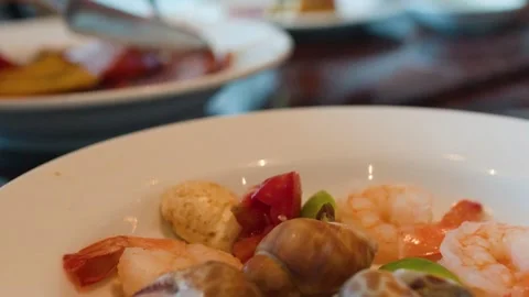 Serving Fresh Seafood Buffet with Sea Snails and Shrimp on White Plate Stock Footage 335799595
