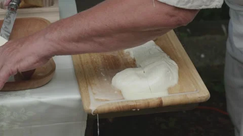 Serving freshly made and sliced traditional sheep cheese Stock Footage 314551996