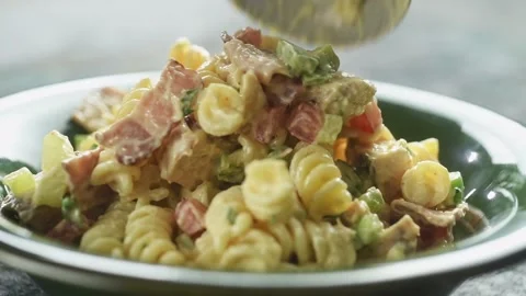 Serving freshly prepared chicken pasta salad into a plate. Stock Footage 198533774