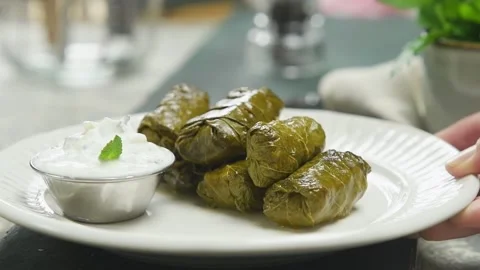 Serving the freshly prepared Dolmas - stuffed grape leaves. Stock Footage 207020706