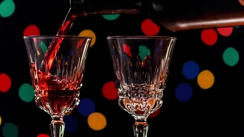 Serving glasses of red wine with colorful bokeh of lanterns at dark background Stock Footage 100975490