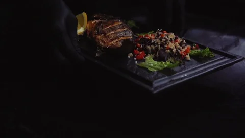 Serving grilled fish on a black background Stock Footage 121723162