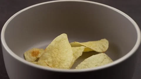 Serving homemade circular potato chips in a gray ceramic bowl slow motion Stock Footage 280089879
