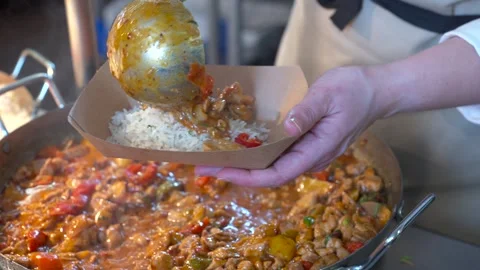 Serving Hot Curry From Large Pan Into Cardboard Tray Stock Footage 321366728