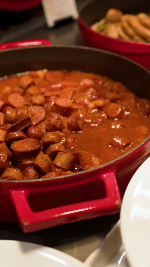 Serving Hot Sausage Stew from a Red Pot at a Buffet Stock Footage 333658915