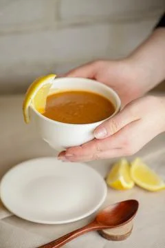 Serving hot soup with a slice of lemon in a cozy setting 库存照片