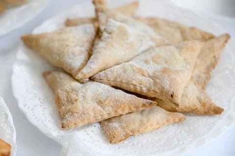 A serving of hot triangular puff pastry with powdered sugar Stock Photos