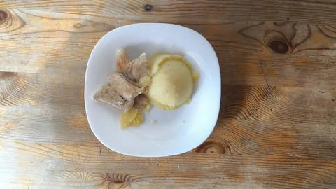 Serving of mashed potatoes and fried meat pieces on white plate Foto stock
