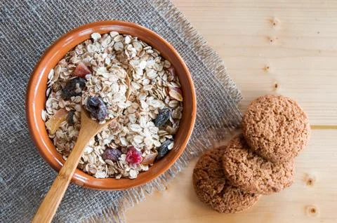 Serving muesli scattering of oat cookie on wooden table Stock Photos