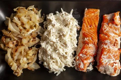 A serving of oven cooked marinated salmon fillets with cabbage and celery sal Stock Photos