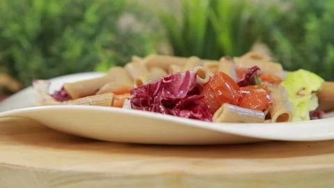 Serving penne pasta with vegetable salad on a plate Stock Footage 340551192
