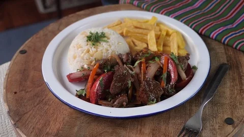 Serving peruvian dish Lomo Saltado in slow motion Stock Footage 83940478