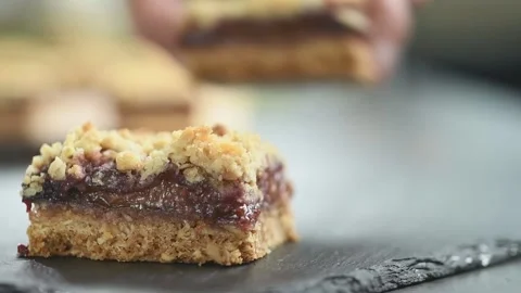 Serving a piece of plum crumble bars. 스톡 동영상 169799750